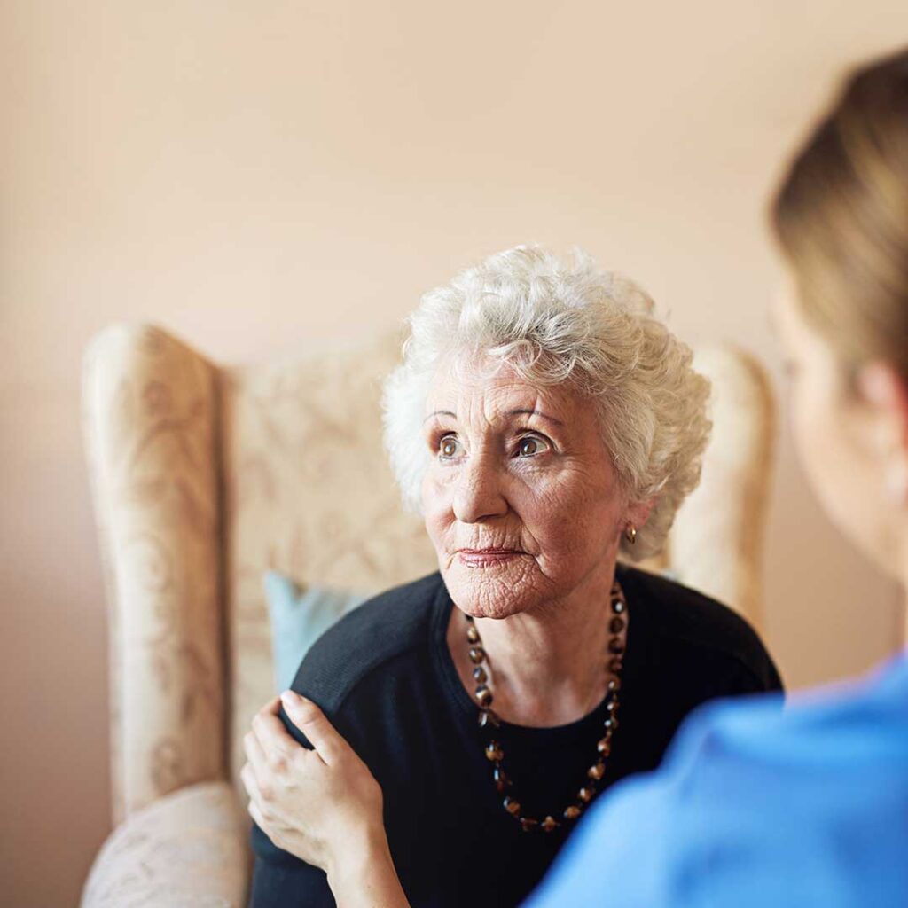 Older adult reviewing assisted living costs with a family member at a kitchen table